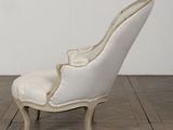 a white chair sitting on top of a wooden floor next to a white wall