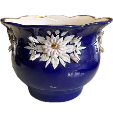 un vase bleu orné d'une fleur blanche