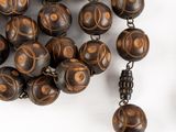 a close up of a necklace with beads on a white surface