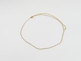 un bracelet en chaîne dorée orné d'un petit pendentif en forme de cœur sur un fond blanc