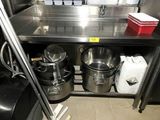 les nombreuses casseroles et poêles qui se trouvent sur l'étagère de la cuisine