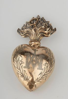 an image of a gold heart shaped brooch with a cross on it