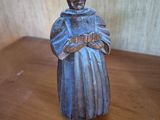 a statue of a man holding a book on a wooden table