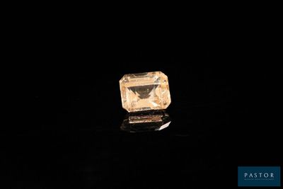 un diamant jaune sur une surface noire, avec un fond noir