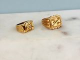 two gold rings sitting on top of a marble counter top