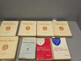 several books are stacked on a table next to each other