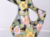 un vase noir et jaune orné de fleurs peintes