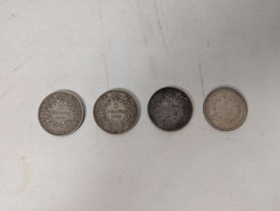 four different types of coins are shown in a row on a white surface