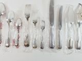 a lot of silver spoons and forks on the table