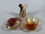 three pieces of glass sitting on a white surface