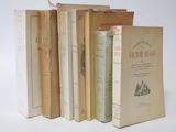 several books are lined up in a row on a white surface