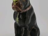 une figurine de chien assise sur une surface blanche