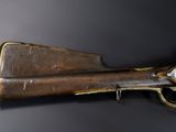 an old gun mounted on a wall in a room