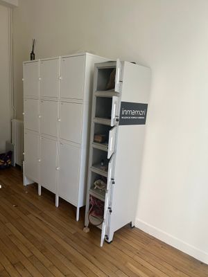 a refrigerator in the corner of a room next to a cabinet