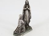 une statue en argent représentant une femme agenouillée à côté d'un enfant