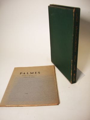 an old book sitting next to a green book on a white surface