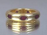 un gros plan d'une bague en or sertie de pierres rouges