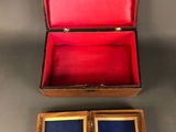 an open wooden box with two small blue and red boxes inside