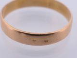a close up of a gold ring on a white surface