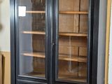 a black cabinet with glass doors in a room