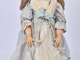une poupée qui porte une robe et des chaussures