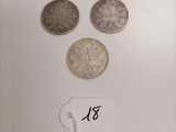 three different types of coins on a white surface with a price tag