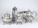 three pieces of silver tea and coffee set on a white surface