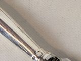 a close up of a silver and black pen on a white surface