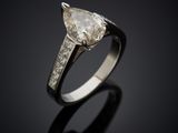 an engagement ring with a pear shaped diamond set in 18k white gold