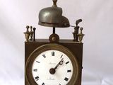 une horloge surmontée d'une cloche, sur fond blanc