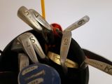 many golf clubs in a black cup on the table