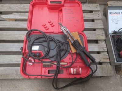une caisse rouge contenant des outils, posée sur une palette