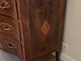 a marble top chest of drawers in the corner of a room