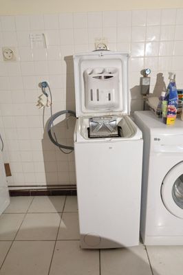 deux lave-linge et un sèche-linge dans une petite pièce