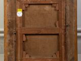 an old wooden picture frame with a label on it sitting on a floor