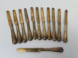 six antique silverwares and a knife on a white surface
