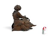 an image of a statue of a woman sitting on a rock