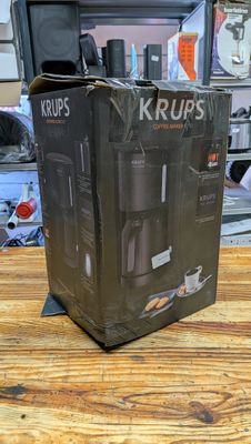packaging for a krups coffee maker on a wooden table
