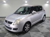 silver suzuki swifter parked on a checkered floor in a garage
