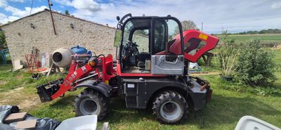 un tracteur rouge garé dans l'herbe