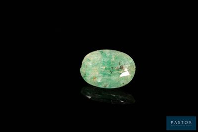 un gros plan d'une émeraude verte sur une surface noire