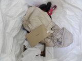 a pile of clothes and shoes on a bed