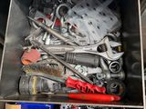 a metal box filled with assorted tools on a table