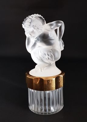 a white figurine sitting on top of a gold base