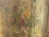 a gold painted room divider with a bunch of flowers on it