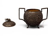 an old metal pot with a lid sitting next to a small metal object