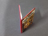 a small book with a red cover sitting on a table