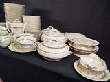 many plates and bowls on a table with a black background