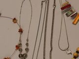 many different necklaces and bracelets laid out on a table
