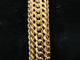 a close up of a gold bracelet on a black background